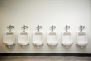 A row of six urinals await customers.